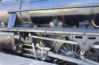 Steam Trains have metal wheels and you can see the pistons which drive them
