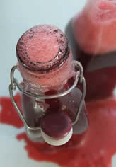 raspberry cordial in kilner bottle and spilling over the work top